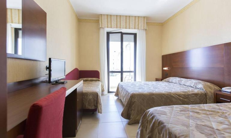 Bright room with cozy beds, elegant furnishings, and a relaxing view.